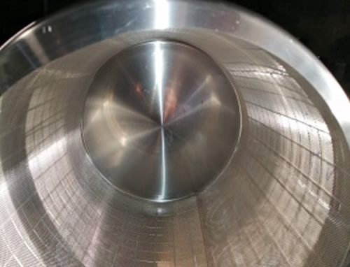 Вътрешността на сребрист метален барабан на сушилня за семена в близък план