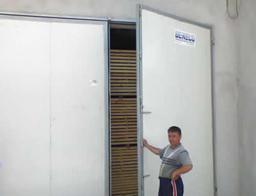 Работник открехва врата на сушилня МКД заредена с дървен материал
